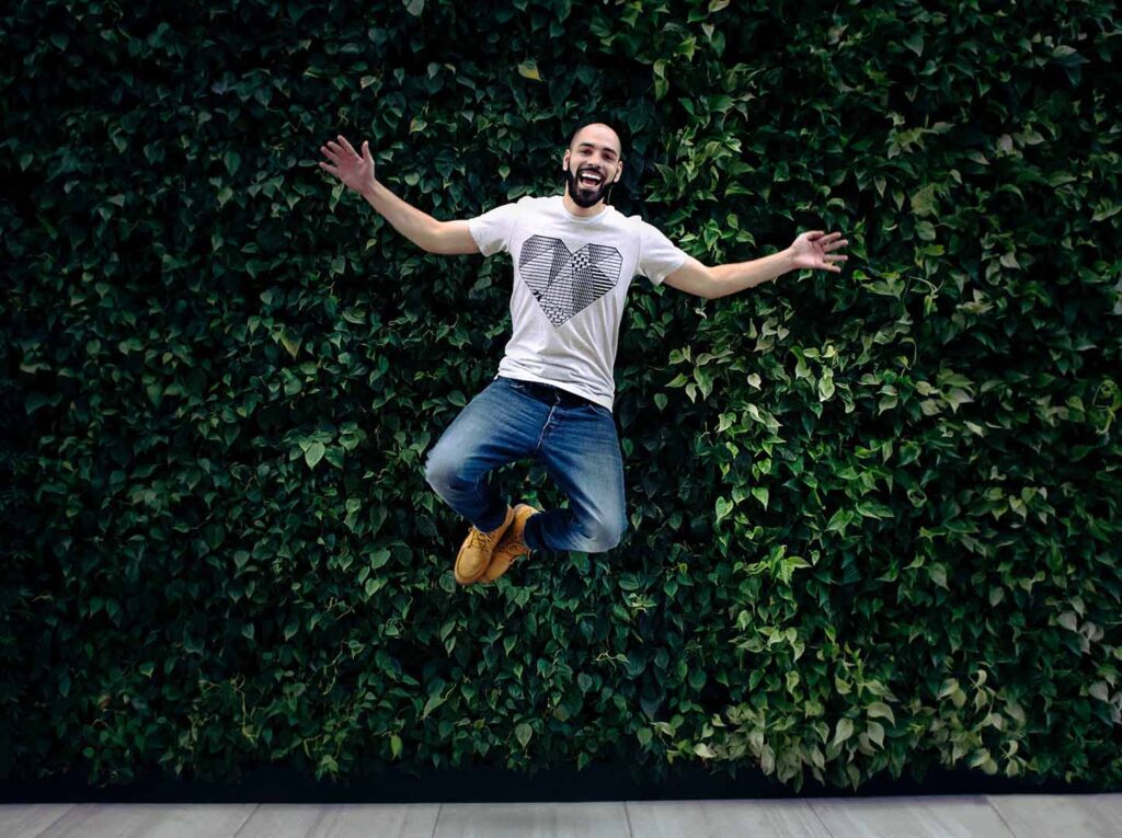 A man jumping in the air with his hands outstretched.